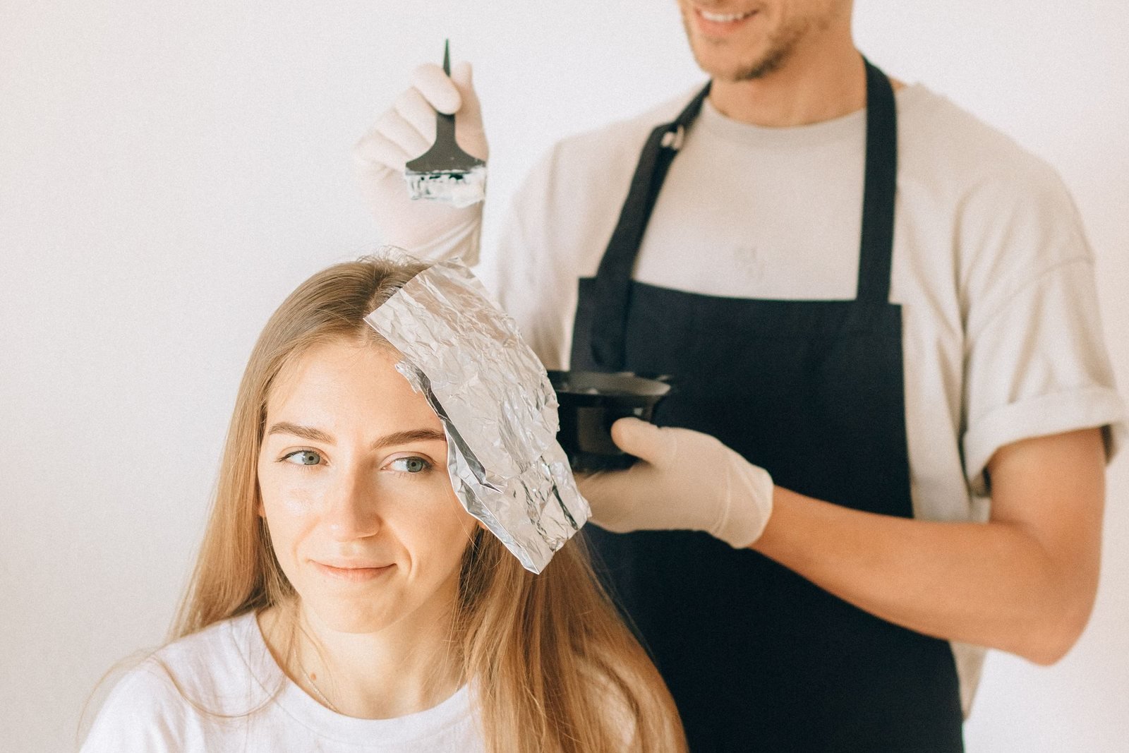 Una parrucchiera controlla il colore dei capelli di una cliente